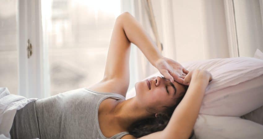 Woman in Gray Tank Top Lying on Bed
